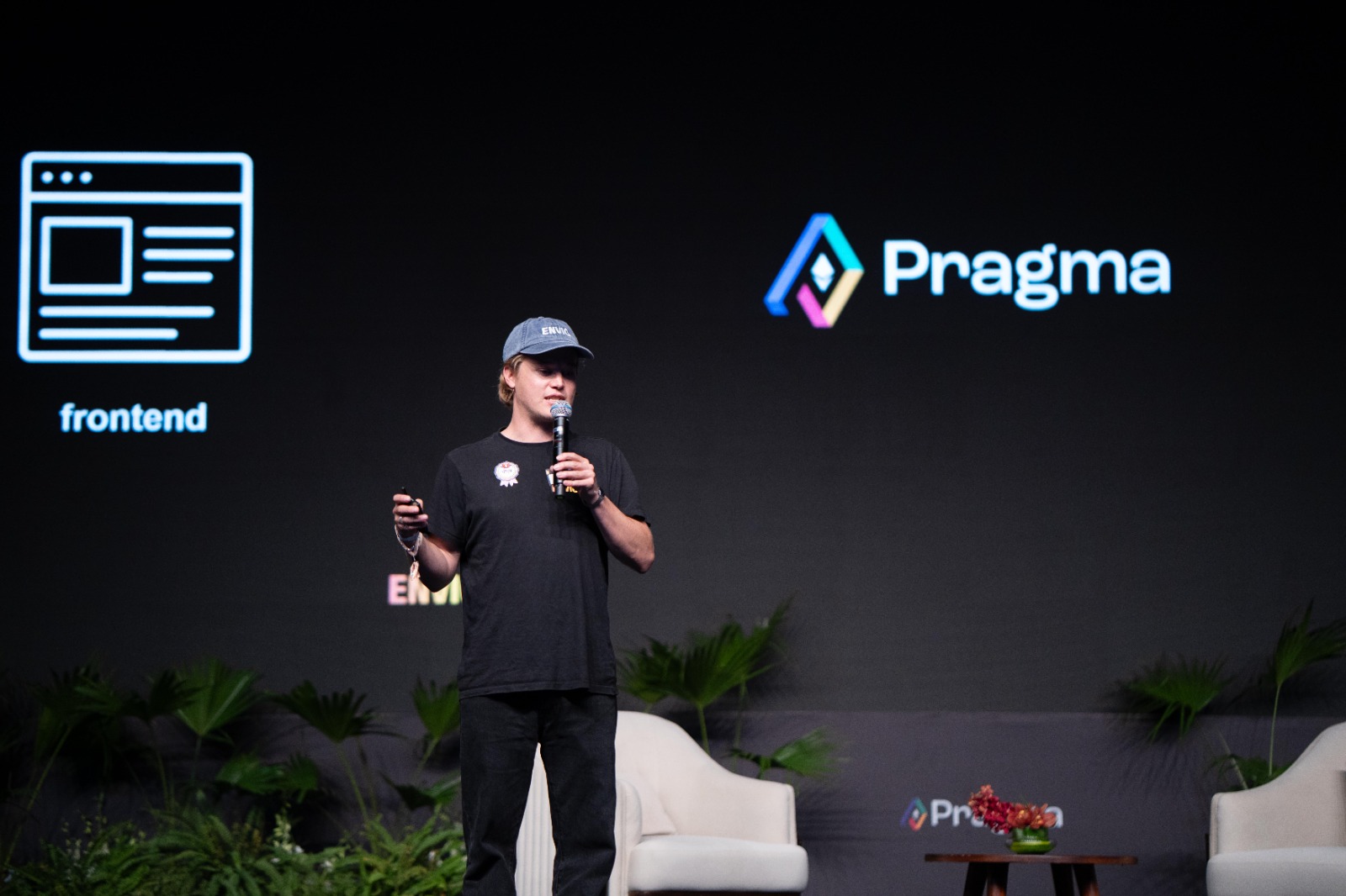 Envio speaker on stage at Pragma in New Delhi with a Pragma logo and frontend slide projected behind